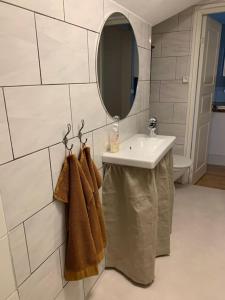 a bathroom with a sink and a mirror and towels at Lägenhet i sekelskiftesvilla i centrala Dalsjöfors in Dalsjöfors