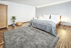 een witte slaapkamer met een bed en een tapijt bij U JOSÍFKA in Pavlov