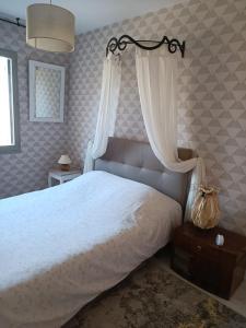 a bedroom with a white bed with a canopy and curtains at Villa les Doms in Mazan