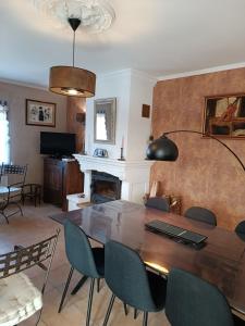 a dining room with a table and chairs and a fireplace at Villa les Doms in Mazan