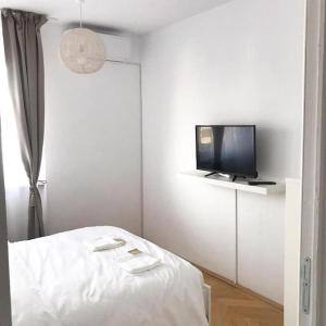 a white room with a bed and a tv at Joy City Stay Victoriei 7E-30 2 in Timişoara