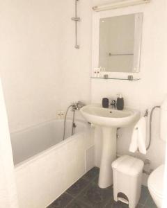 uma casa de banho branca com um lavatório e uma banheira em Joy City Stay Victoriei 7E-30 2 em Timisoara