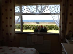 a bedroom window with a view of the eiffel tower at Seafront BNB in Quilty