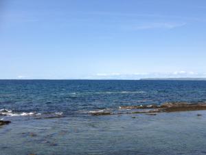 a large body of water with rocks in it at Seaside Accomodation in Quilty