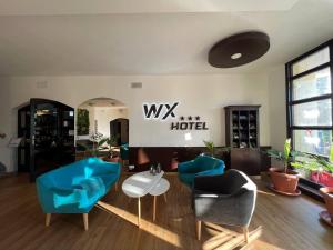 WX Hotel في براتيسلافا: غرفة معيشة مع كراسي زرقاء وطاولة