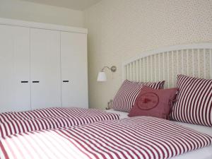 a bedroom with two beds with red and white striped pillows at Holiday apartment Domstag in Kronsgaard