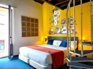 a bedroom with a bed and a yellow wall at Casual Ilbira Granada by Casual Hoteles in Granada +50 photos