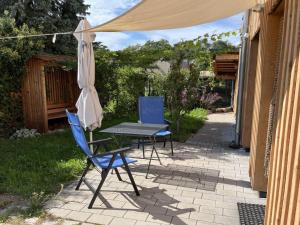 a table and chairs and an umbrella on a patio at Holiday apartment Weinberghäusle in Sasbach am Kaiserstuhl