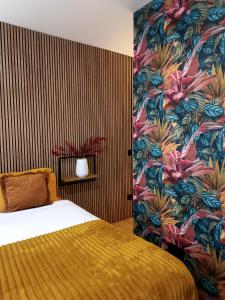 1 dormitorio con 1 cama y una pared colorida en Fridda House Atocha Madrid, en Madrid