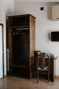 un armario de madera con una silla junto a una mesa en Guardanapoli, en Cervino