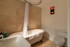 a bathroom with a tub and a toilet and a sink at GuestReady - A Bohemian Home in Bath in Bath +11 photos