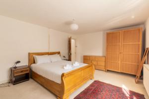 a bedroom with a bed and a wooden cabinet at GuestReady - A Bohemian Home in Bath in Bath