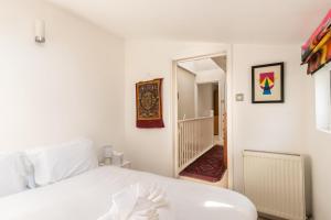 a bedroom with a white bed and a hallway at GuestReady - A Bohemian Home in Bath in Bath