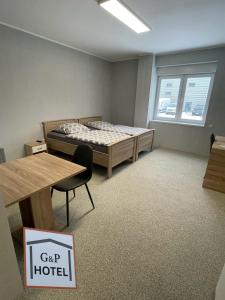 勒沃庫森的住宿－GPHotel/Boardinghaus，客房设有一张床、一张桌子和一张桌子。