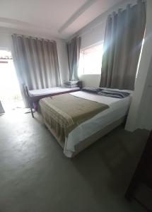 a bedroom with two beds and a window at Suítes Viver Bahia Morro Sao Paulo in Morro de São Paulo