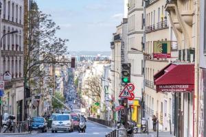 een drukke straat met auto's en verkeerslichten bij Appartement 4 personnes Oberkampf in Parijs