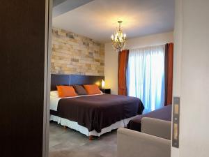 a bedroom with a bed with orange pillows and a window at Apart & Hotel Neptuno in Valeria del Mar