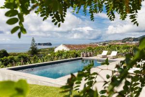 a swimming pool with a view of the ocean at Guava Azores II in Ribeira das Tainhas