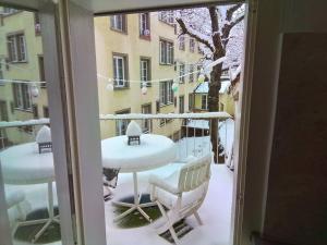 a balcony with a table and chairs covered in snow at tiny flat in St. Gallen