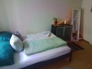 a bed with pillows on it in a room at tiny flat in St. Gallen