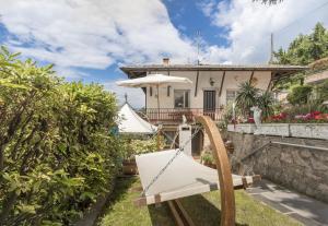 una casa con una hamaca en el patio en Casa Aria lake view, en San Zeno di Montagna