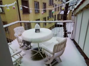 un tavolo e sedie ricoperti di neve su un balcone di tiny flat a St. Gallen