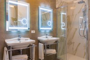 ポルトフェッラーイオにあるホテル ヴィラ オットーネのバスルーム(シンク2台、シャワー付)