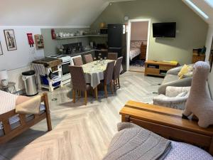 Alpaca Lodge في سيتينغبورن: غرفة معيشة مع طاولة طعام ومطبخ