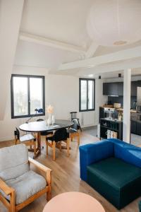 salon z niebieską kanapą i stołem w obiekcie Maison Passage w mieście Trinité-sur-Mer