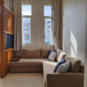 a living room with a couch and two windows at Le Petit Bijou in Tetouan