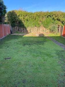 a large grass yard with a fence and a field at 3BD Sanctuary in Beeston, Nottinghamshire in Beeston