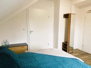 a bedroom with a blue bed and a closet at Wohnen am Schlosspark in Bad Salzuflen