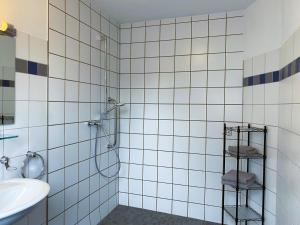 a white tiled bathroom with a shower and a sink at Wohnen am Schlosspark in Bad Salzuflen
