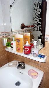 a bathroom sink with hygiene products on a shelf at Résidence Faouazi in Casablanca