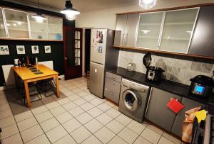 eine Küche mit einer Waschmaschine und einem Tisch in der Unterkunft ANAND HOUSE in Harrow