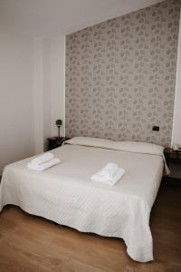 a bedroom with a white bed with two towels on it at Guardanapoli in Cervino