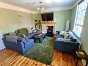 a living room with two couches and a fireplace at The Hideaway - Central Townhouse in Wareham