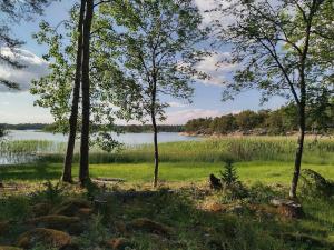 un campo con árboles y un cuerpo de agua en Västeräng Glamping en Lillandet