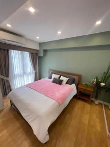 a bedroom with a large bed and a window at KAMALA 503 ACACIA ESTATE TAGUIG CITY in Manila