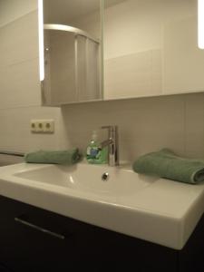 Apartment Pilz في غوساو: بالوعة بيضاء مع صنبور ومرآة