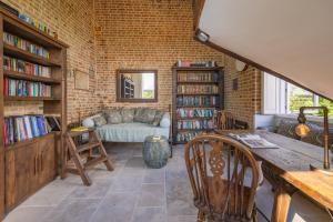 - un salon avec un mur en briques et un canapé dans l'établissement Burnt House Alfriston, Sussex (London-95 mins), à Alfriston