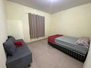 una camera da letto con un letto e un divano di Loft 1 Sítio do Barrigudinho a Saquarema Altre 6 foto