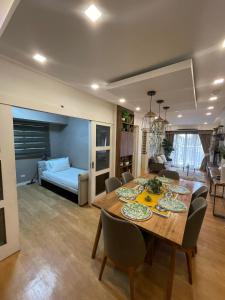 a dining room with a table and chairs and a living room at KAMALA 503 ACACIA ESTATE TAGUIG CITY in Manila