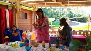 a woman standing in front of a table with two girls at Camping La Digue in Chauzon