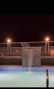 - une fontaine au milieu d'une piscine la nuit dans l'établissement Casa En Montana, à Kārli