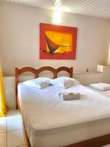 a bedroom with two beds and a painting on the wall at Felicità Praia Hotel in Fortaleza