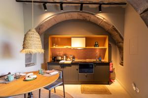 uma cozinha com uma mesa e uma cozinha com um arco em Guava Azores II em Ribeira das Tainhas