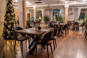 a restaurant with tables and chairs and a christmas tree at Hotel Szelców in Lesko