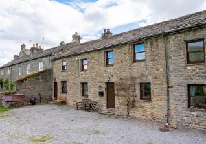 ein altes Steinhaus mit einem Innenhof davor in der Unterkunft 5 Swallowsholm Cottage in Richmond