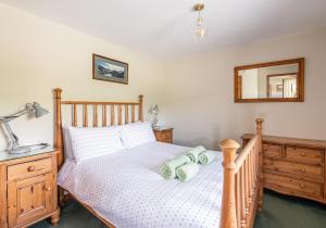 Schlafzimmer mit einem Holzbett und einem Spiegel in der Unterkunft 5 Swallowsholm Cottage in Richmond